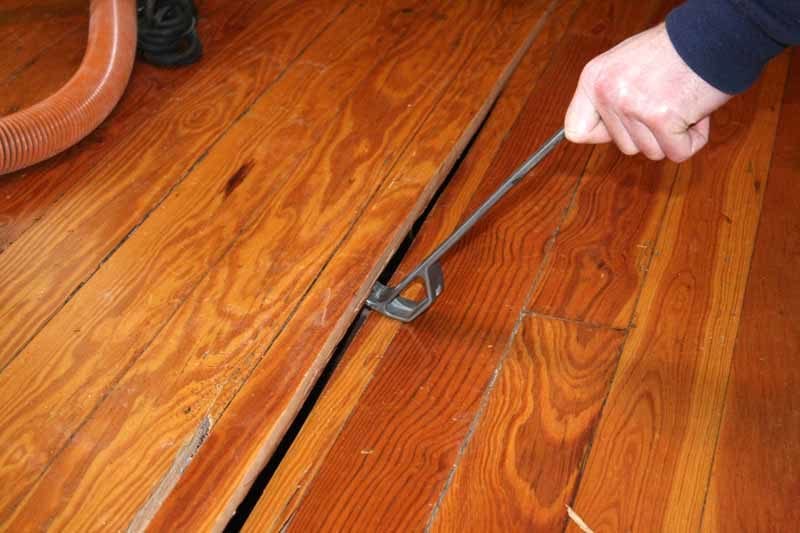 Using a pry bar to remove 3/4-inch flooring