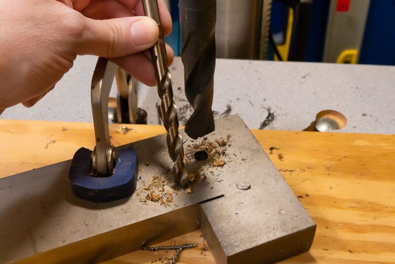 Make a pilot hole before drilling through thick metal