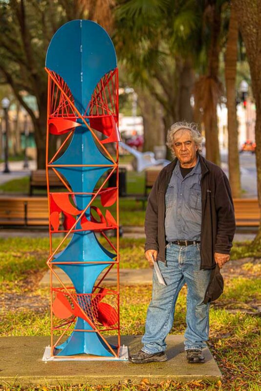 Sculptor Hanna Jubran with his completed work secured to a concrete pad using wedge anchors